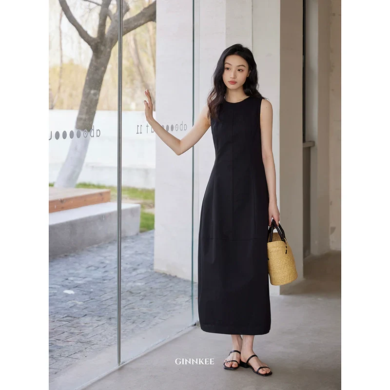 Sleeveless Maxi Dress Paired with a Woven Straw Handbag - Image 4