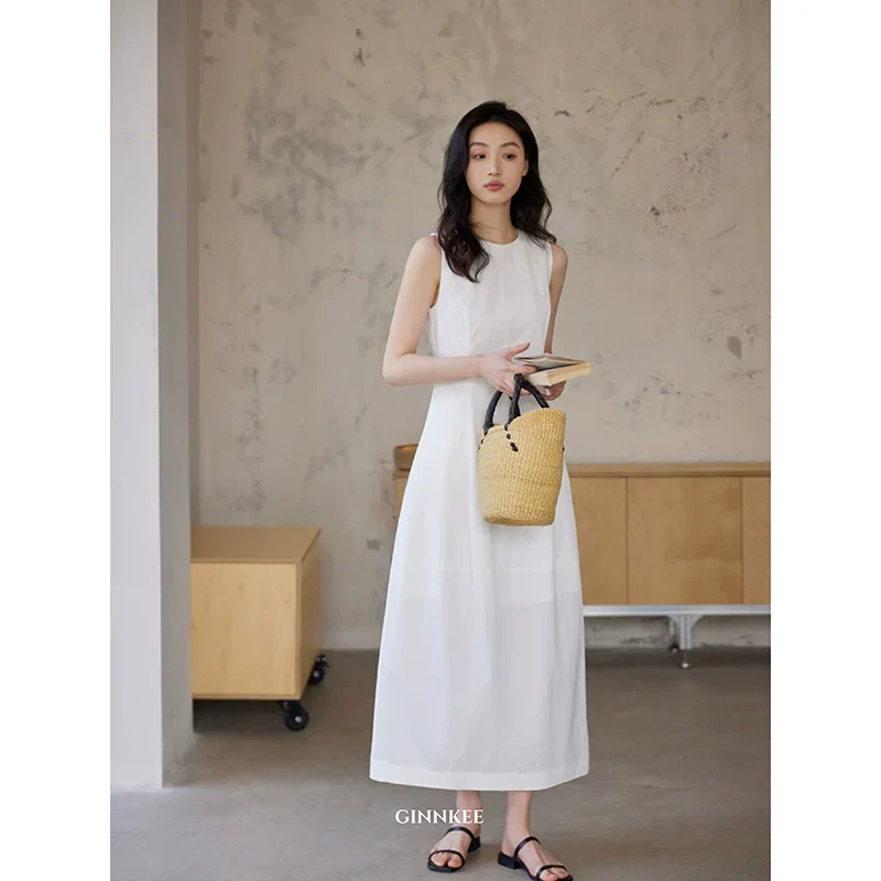 Sleeveless Maxi Dress Paired with a Woven Straw Handbag - Image 5